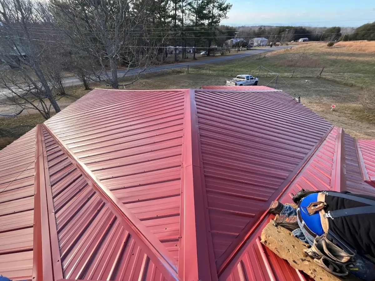 Red ribbed metal roof hip detail on a residential home